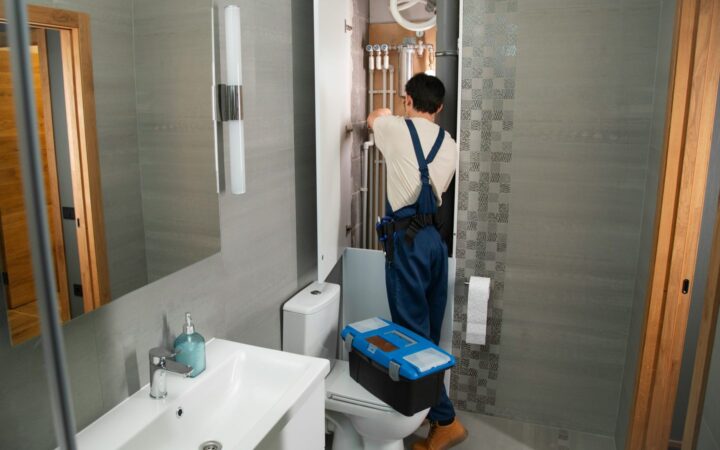 VVS-installatør arbejder ved en vandinstallation i et badeværelse