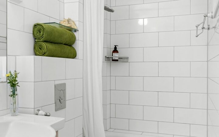 Lyst badeværelse med håndvask, toilet og bruseområde