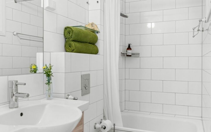 Lyst badeværelse med håndvask, toilet og bruseområde