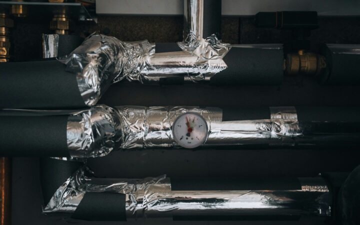 Isolerede varmerør med temperaturmåler i teknisk installation